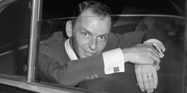 Hollywood singer, Frank Sinatra, is seen here looking quizzically into a press camera shortly after a conference with the Rome press where he denied reports that he had been booed and called off the stage of a Naples theater. The incident supposedly occurred when Sinatra's wife, actress Ava Gardner, billed to appear with him, failed to keep the engagement. According to press reports, the disappointed fans protested violently and walked out on the Sinatra performance. Nancy Olson Livingston said her husband, Alan W. Livingston, took a chance on the singer.