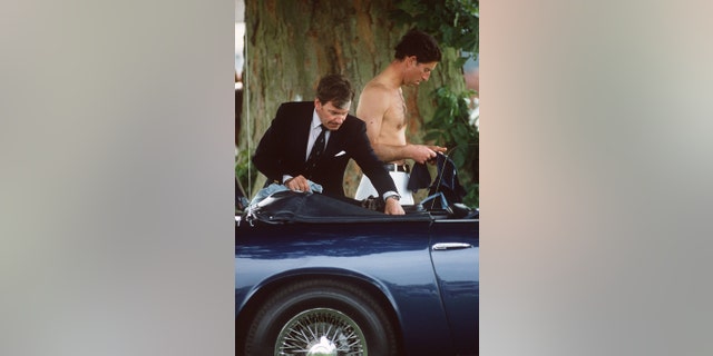 Then-Prince Charles being helped by his valet, Ken Stronach, during a game of polo. The sports car was a birthday gift to the prince from his mother, Queen Elizabeth II.