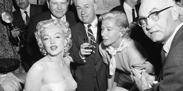 Actress Marilyn Monroe, left, is surrounded by photographers and journalists as she is interviewed by Phyllis Battelle, right. Nancy Olson Livingston described her first meeting with the blonde bombshell as "bizarre."