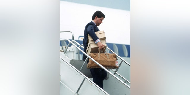 Michael Fawcett, Prince Charles's valet, carrying his luggage off a royal flight, circa 1990s.