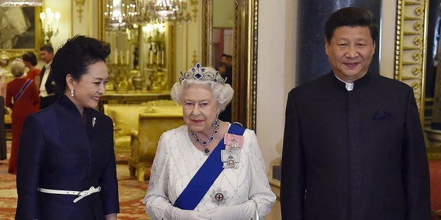 President of China Xi Jinping (R) and his wife Peng Liyuan (L) accompany Britain's Queen Elizabeth II as they arrive for a state banquet at Buckingham Palace on October 20, 2015, in London, England. The queen is seen wearing the sapphire tiara for the evening.