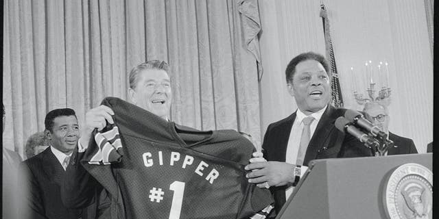 President Reagan holds a shirt given to him by former baseball star Willie Mays after Reagan spoke to campaign workers at the White House. "Gipper, #1," refers to a movie role Reagan played during his Hollywood days, in which he was a football star named George Gipp.