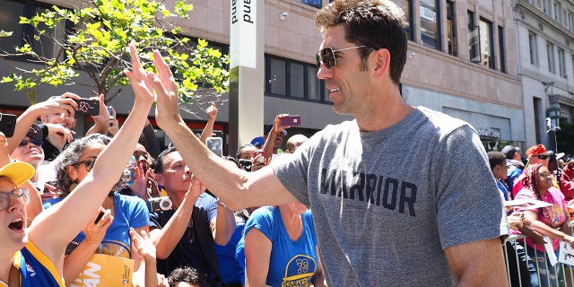 El gerente general de los Golden State Warriors, Bob Myers, choca los cinco durante el desfile del campeonato en el centro de Oakland, California, el 12 de junio de 2018.