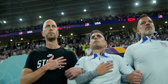 head coach Gregg Berhalter of the United States, left, stands during the national anthem before the World Cup, group B soccer match between the United States and Wales, at the Ahmad Bin Ali Stadium in Doha, Qatar, Monday, Nov. 21, 2022. 