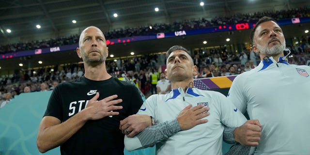 head coach Gregg Berhalter of the United States, left, stands during the national anthem before the World Cup, group B soccer match between the United States and Wales, at the Ahmad Bin Ali Stadium in Doha, Qatar, Monday, Nov. 21, 2022. 