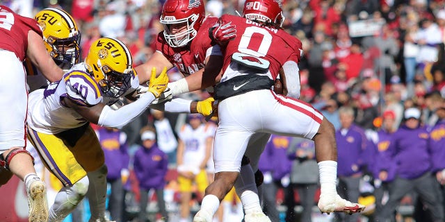 Razorbacks running back AJ Green, right, evades LSU Tigers linebacker Harold Perkins Jr., left, on Nov. 12, 2022, in Fayetteville, Arkansas.