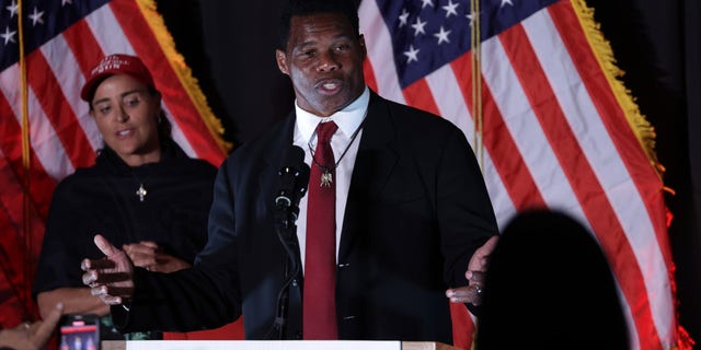 Republican U.S. Senate candidate Herschel Walker speaks to supporters as his wife Julie Blanchard looks on during an election night event on Nov. 8, 2022, in Atlanta. 