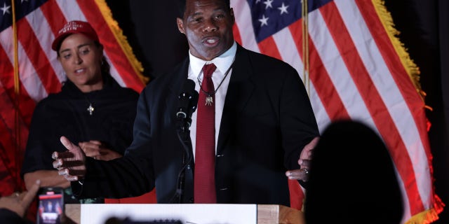 Republican U.S. Senate candidate Herschel Walker speaks to supporters as his wife Julie Blanchard looks on during an election night event on Nov. 8, 2022, in Atlanta. 