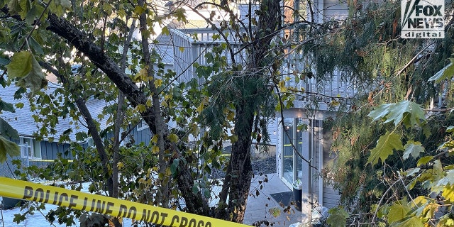 The backyard of an off-campus house where the victims were slain can be seen through police tape.