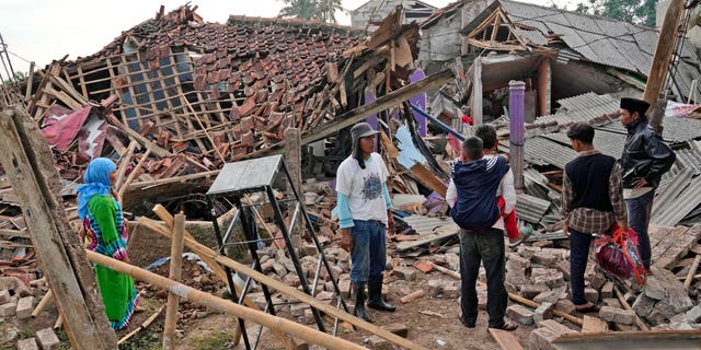 People inspect the ruins of their houses badly damaged in Monday's earthquake in Cianjur, West Java, Indonesia Tuesday, Nov. 22, 2022. 