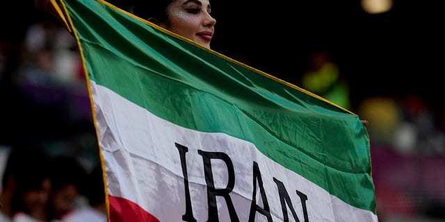 A soccer fan holds a flag from Iran prior to the World Cup Group B soccer match between Wales and Iran, at the Ahmad Bin Ali Stadium in Al Rayyan, Qatar.