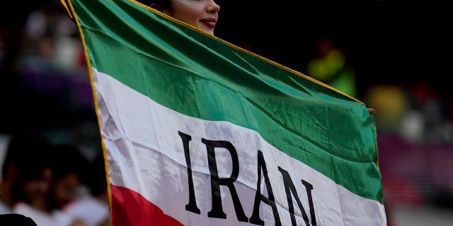 A soccer fan holds a flag from Iran prior to the World Cup Group B soccer match between Wales and Iran, at the Ahmad Bin Ali Stadium in Al Rayyan, Qatar.