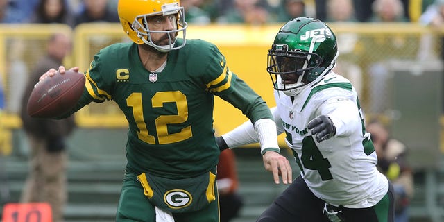 New York Jets defensive end Jacob Martin (54) chases down Green Bay Packers quarterback Aaron Rodgers (12) during a game between the Green Bay Packers and the New York Jets at Lambeau Field on October 16, 2022 in Green Bay, WI.