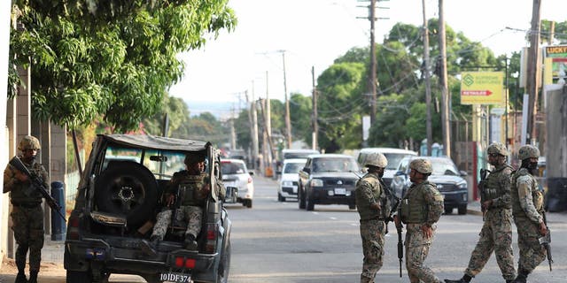 Members of security forces guard the streets as Jamaican Prime Minister Andrew Holness on Tuesday declared a state of public emergency in parts of the capital Kingston, and in some parishes in the central and western parts of the country