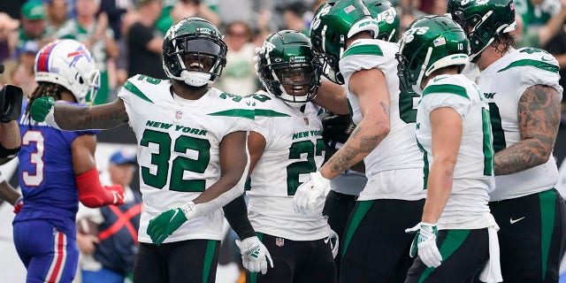 New York Jets running back James Robinson, #23, celebrates with teammates after scoring a touchdown during the second half of an NFL football game against the Buffalo Bills, Sunday, Nov. 6, 2022, in East Rutherford, New Jersey.