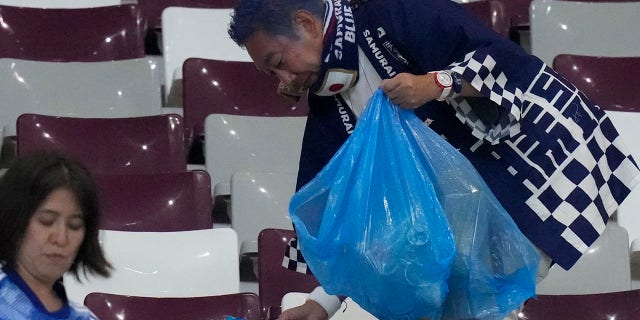2022 fifa world cup Japan supporters clean the stands at the end of the World Cup group E soccer match between Germany and Japan, at the Khalifa International Stadium in Doha, Qatar, Wednesday, Nov. 23, 2022.