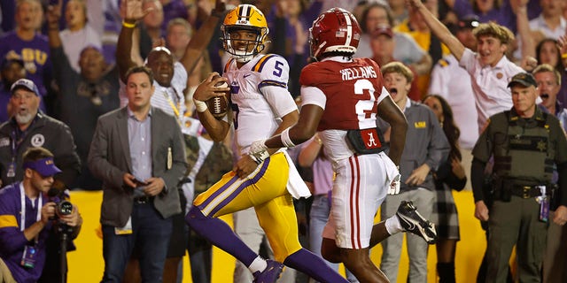 LSU quarterback Jayden Daniels runs the ball past Alabama defensive back DeMarcco Hellams to score a two-point conversion during overtime in Baton Rouge, Louisiana, Saturday, Nov. 5, 2022.