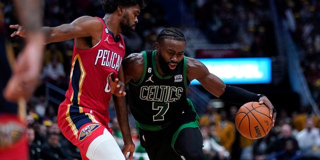 Boston Celtics guard Jaylen Brown hits the hoop against Pelicans forward Naji Marshall on Friday, November 18, 2022, in New Orleans.