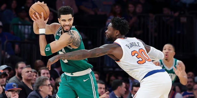 Boston Celtics forward Jayson Tatum shields the ball from New York Knicks forward Julius Randle, #30, during the second half of an NBA basketball game Saturday, Nov. 5, 2022, at Madison Square Garden in New York.
