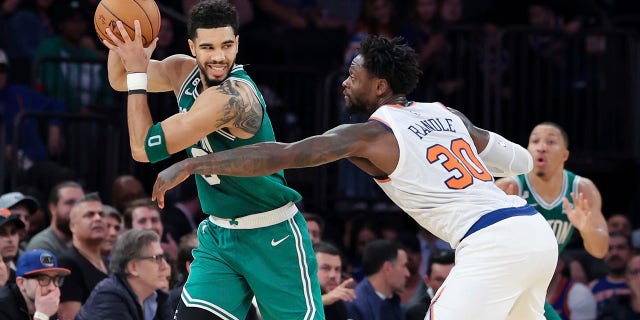 Boston Celtics forward Jayson Tatum shields the ball from New York Knicks forward Julius Randle, #30, during the second half of an NBA basketball game Saturday, Nov. 5, 2022, at Madison Square Garden in New York.