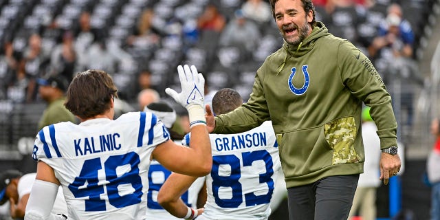 El entrenador en jefe interino de los Indianapolis Colts, Jeff Saturday, a la derecha, saluda al ala cerrada Nikola Kalinic antes de un partido de fútbol americano de la NFL contra Los Vegas Raiders en Las Vegas el domingo 13 de noviembre de 2022. 