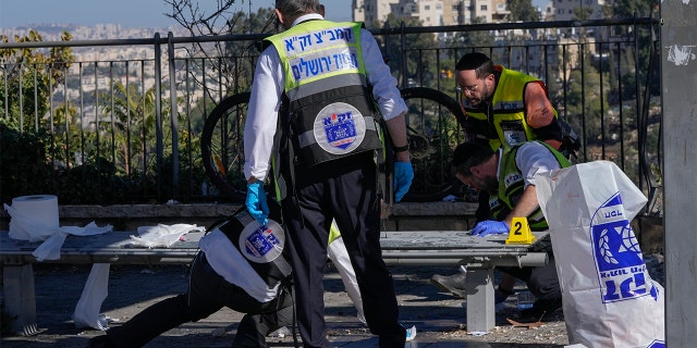 Members of Zaka Rescue and Recovery team clean blood from the scene of an explosion at a bus stop in Jerusalem, Wednesday, Nov. 23, 2022. 