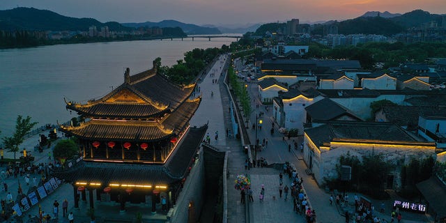 Uma foto aérea tirada em 2 de maio de 2021 mostra a visão noturna da cidade antiga de Yanzhou no município de Meicheng, cidade de Jiande, na província de Zhejiang, no leste da China.  A cidade antiga recebeu um total de 114.000 visitantes no sábado e domingo.