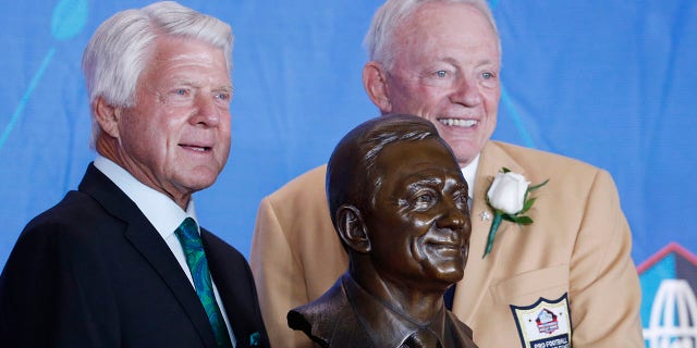 Dallas Cowboys owner Jerry Jones and presenter Jimmy Johnson pose with a bust of Jones during the Pro Football Hall of Fame Consecration Ceremony at the Tom Benson Hall of Fame Stadium on August 5, 2017, in Canton, Ohio.