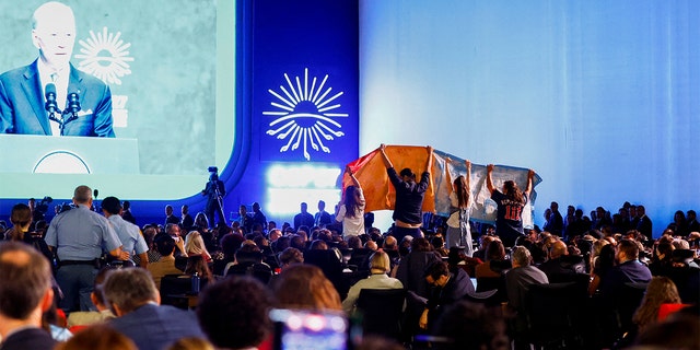 Climate activists protest as President Biden delivers a speech at the COP27 climate summit.