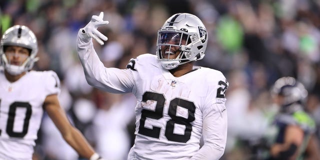 Josh Jacobs (28) of the Las Vegas Raiders celebrates after scoring a touchdown in overtime to beat the Seattle Seahawks at Lumen Field on November 27, 2022 in Seattle, Washington.