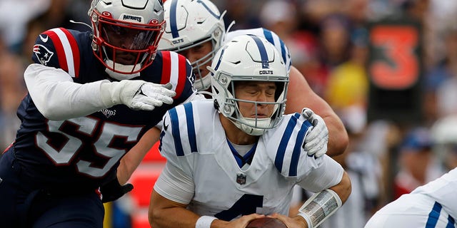 Indianapolis Colts quarterback Sam Ehlinger, front right, is brought down by New England Patriots linebacker Josh Uche (55) in the first half of an NFL football game, Sunday, Nov. 6, 2022, in Foxborough, Mass. 