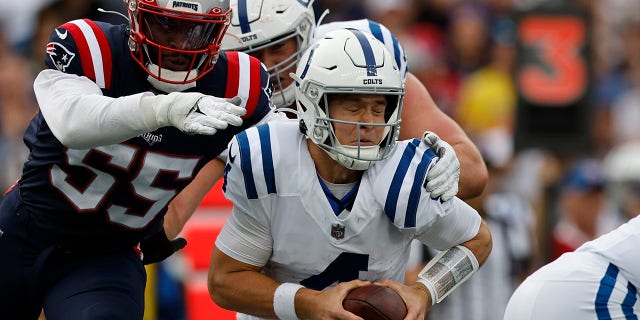 Indianapolis Colts quarterback Sam Ehlinger, front right, is brought down by New England Patriots linebacker Josh Uche (55) in the first half of an NFL football game, Sunday, Nov. 6, 2022, in Foxborough, Mass.