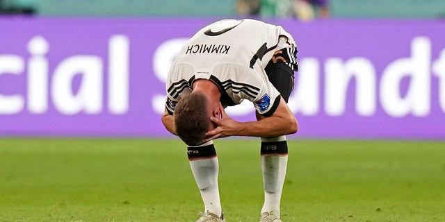 Germany's Joshua Kimmich reacts after Japan scored during a World Cup Group E soccer match between Germany and Japan at the Khalifa International Stadium in Doha, Qatar, Wednesday, Nov. 23, 2022. 