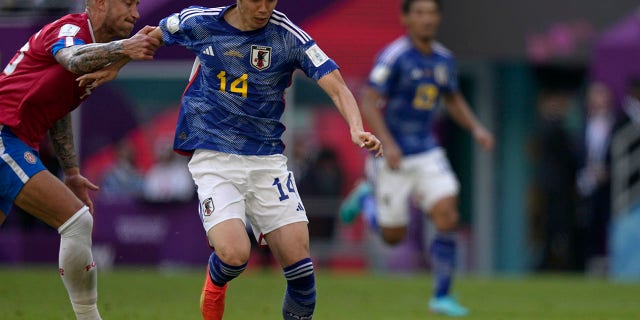 Junya Ito of Japan duels for the ball with Francisco Calvo of Costa Rica during the World Cup group E match in Al Rayyan, Qatar, Sunday, November 27, 2022.