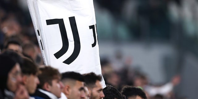Los fanáticos de la Juventus sostienen una pancarta con el logo del club durante un partido de la Serie A contra el FC Internazionale en el estadio Allianz el 6 de noviembre de 2022 en Turín, Italia.