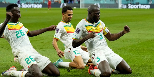 Senegal's Kalidou Koulibaly, right, celebrates with teammates during the World Cup match against Ecuador at the Khalifa International Stadium in Doha, Qatar, Tuesday, November 29, 2022.