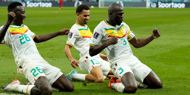 Senegal's Kalidou Koulibaly, right, celebrates with teammates during the World Cup match against Ecuador at the Khalifa International Stadium in Doha, Qatar, Tuesday, November 29, 2022.