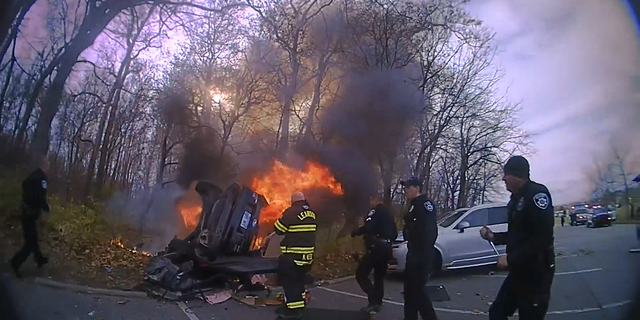 First responders are seen approaching the burning vehicle in Leawood, Kansas, on Monday.