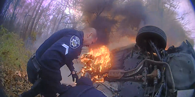 The bodycam video from the Leawood Police Department shows officers getting close to the flames to rescue the woman.