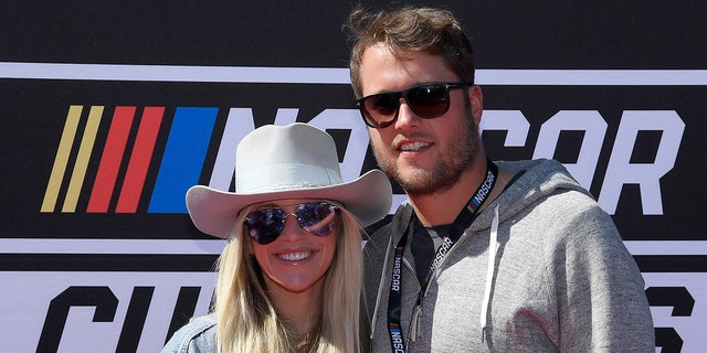 Super Bowl champion quarterback Matthew Stafford, #9 of the Los Angeles Rams, and his wife and Kelly pose on the red carpet before the start of NASCAR Cup Series Wise Power 400 at the Auto Club Speedway on Feb. 27, 2022 in Fontana, California.