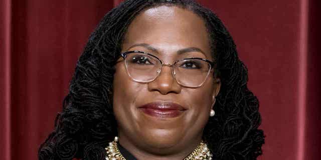 Associate Justice Ketanji Brown Jackson stands as she and members of the Supreme Court pose for a new group portrait following her addition, at the Supreme Court building in Washington, Oct. 7, 2022.