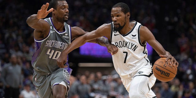L'attaccante dei Brooklyn Nets Kevin Durant, numero 7, è difeso dall'attaccante dei Sacramento Kings Harrison Barnes, numero 40, nel primo quarto di una partita di basket NBA a Sacramento, California, martedì 15 novembre 2022.