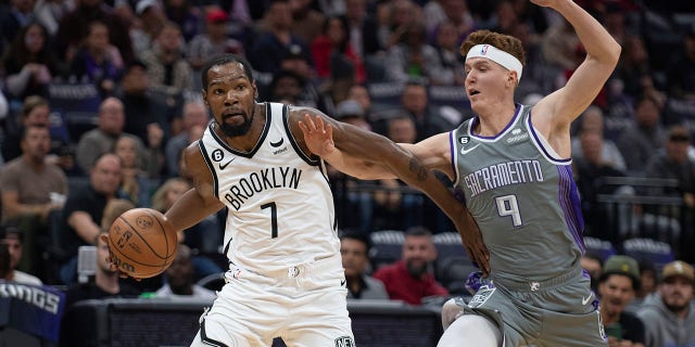 Brooklyn Nets forward Kevin Durant, #7, is guarded by Sacramento Kings guard Kevin Huerter, #9, in the first quarter of an NBA basketball game in Sacramento, California, Tuesday, Nov. 15, 2022. 