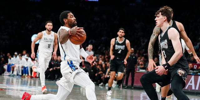 Brooklyn Nets guard Kyrie Irving dribbles against Memphis Grizzlies forward Jake LaRavia, Sunday, Nov. 20, 2022, in New York.