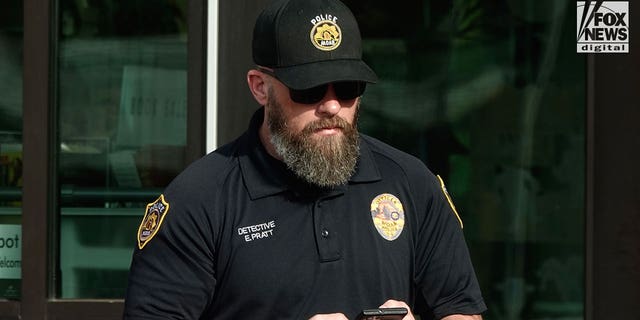 Moab Police officer, Eric Pratt is seen on his phone in Moab Utah, Saturday, October 29, 2022. 
