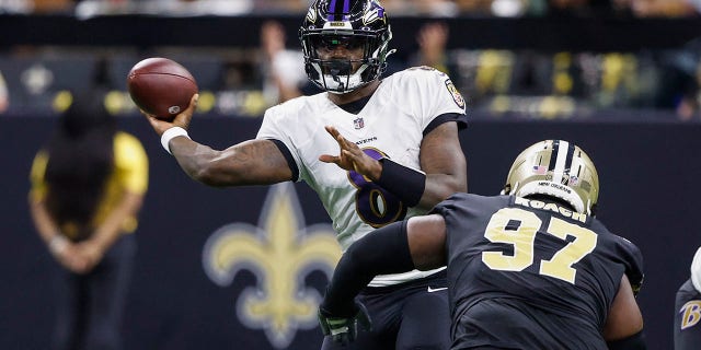 Baltimore Ravens quarterback Lamar Jackson, #8, passes under pressure from New Orleans Saints defensive end Malcolm Roach, #97, in the second half of an NFL football game in New Orleans, Monday, Nov. 7, 2022.