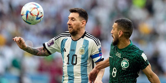 Argentina's Lionel Messi, left, and Saudi Arabia's Abdulelha Al-Malki fight for the ball during the World Cup group C soccer match between Argentina and Saudi Arabia at Lusail Stadium in Lusail, Qatar, Tuesday November 22, 2022.