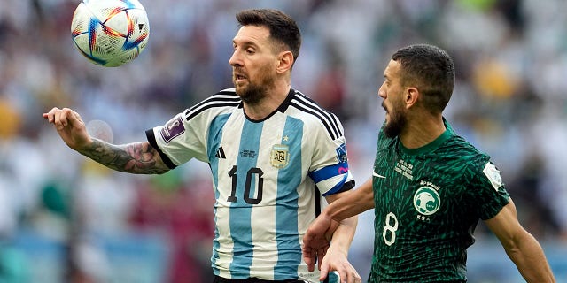 Argentina's Lionel Messi, left, and Saudi Arabia's Abdulelha Al-Malki fight for the ball during the World Cup group C soccer match between Argentina and Saudi Arabia at Lusail Stadium in Lusail, Qatar, Tuesday November 22, 2022.