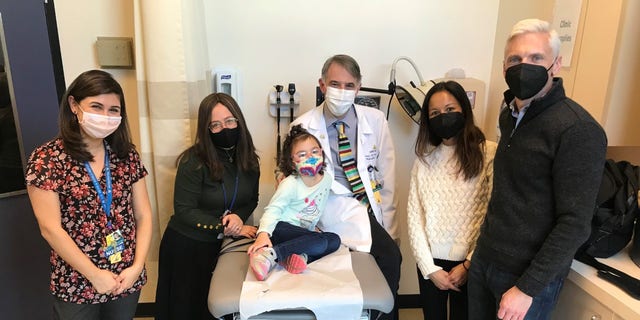 Kyla Luzader, Doug Luzader, his wife, and Kyla’s medical team at Johns Hopkins, including Dr. Eric Kossoff, M.D. (center). 