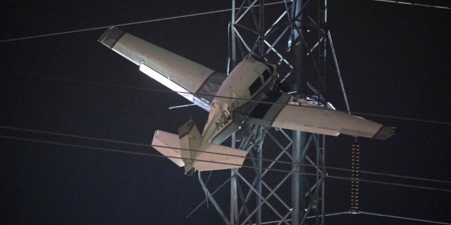 A small plane rests on live power lines after crashing, Sunday, Nov. 27, 2022, in Montgomery Village, a northern suburb of Gaithersburg, Md. 